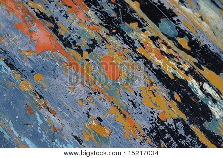 Nice blue and orange colors appearing through different layers of paint on a wooden huts surface central focus.