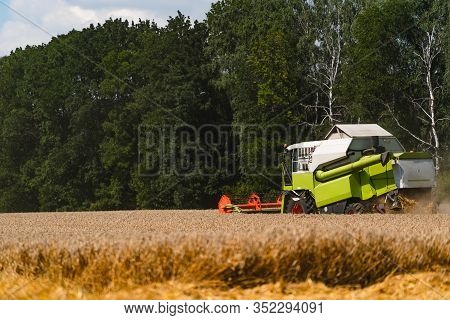 Special Machine Harvesting Crop In Fields. Agricultural Technic In Action. Ripe Harvest Concept. Cro