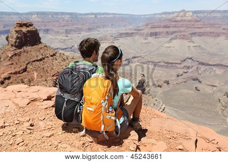 Hikers in Grand Canyon enjoying view of nature landscape. Young couple hiking relaxing during hike on South Kaibab Trail, south rim of Grand Canyon, Arizona, USA.