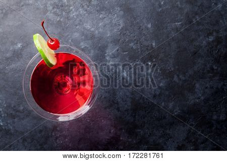 Cosmopolitan cocktail on dark stone table. Top view with space for your text