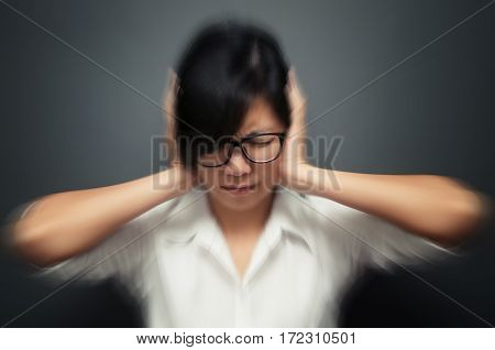 Blurred and de-focused of stress concept. Worried stressed face of asian woman expression. Stressed woman wear glasses headache with migraine headache pain. Business woman holding head with hands.