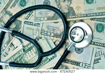 a stethoscope on a pile of US dollar bills, depicting the health care industry concept