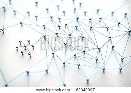 Linking entities. Networking, social media, SNS, internet communication abstract. Small network connected to a larger network. Web of light blue, wires on white background.