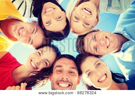 summer, holidays, vacation, happy people concept - group of teenagers looking down