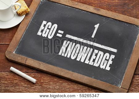 ego and knowledge concept (illustration of Albert Einstein words) on a  vintage slate blackboard with a chalk and  cup of coffee