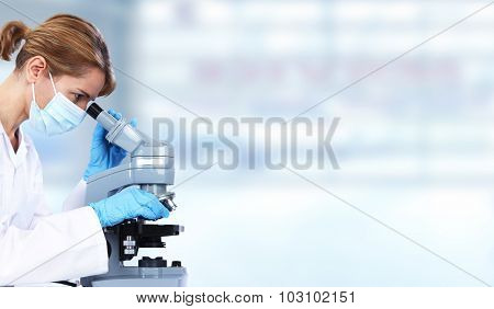 Doctor woman with microscope in laboratory. Scientific research.