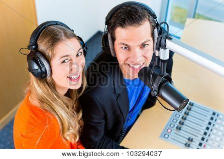 Presenters or moderators - man and woman - in radio station hosting show for radio live in Studio