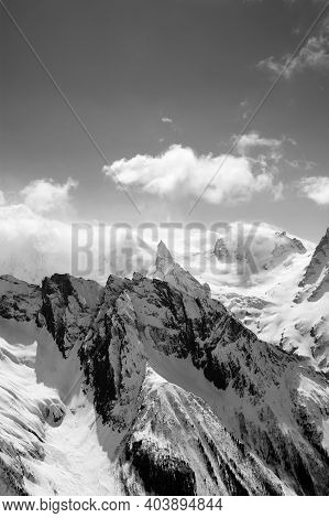 Black And White View On Snowy High Mountains Peak In Sunlit Clouds At Winter Evening. Caucasus Mount