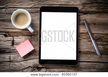 Workspace with coffee cup, tablet pc and note paper on old wooden table