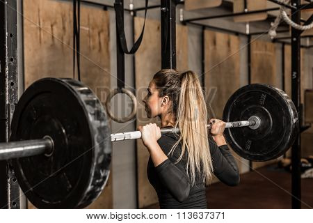 Young female athlete performed squats in the gym