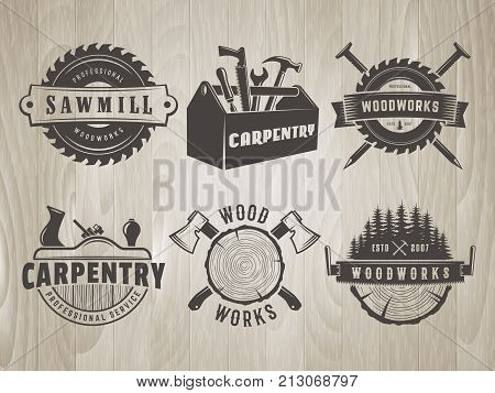 Woodwork logos. Vector badges for carpentry, sawmill, lumberjack service or woodwork shop. Set of hand tools labels on vintage wooden background.