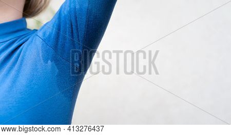 Woman In A Blue Golf Shirt With A Wet Armpit Raised Hand Up On A White Background With Copy Space. C