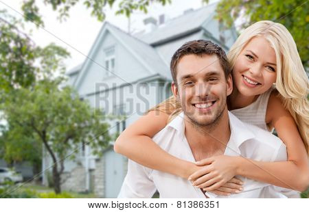 love, people, real estate, home and family concept - smiling couple hugging over house background