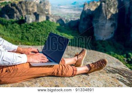 Man with laptop on the mountains