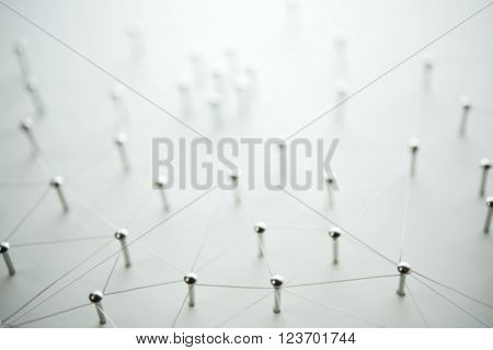 Linking entities, blurred background, or off-focus background. Network, networking, social media, internet communication abstract. Web of thin silver wires on white background.