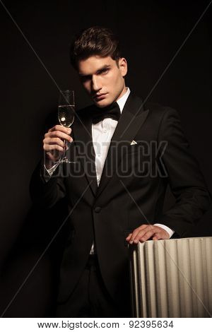 Elegant young business man holding up a glass of champagne.