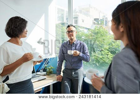 Cheerful Business People Drinking Coffee And Chatting During Break