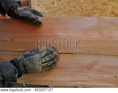 Cleaning The Surface Of Wooden Furniture By Hand Using Sandpaper, Black-gloved Hands Hold The Sandpa