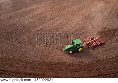 John Deere Tractor With Disc Cultivator Vaderstad Carrier On Cultivating Field. Agricultural Tractor