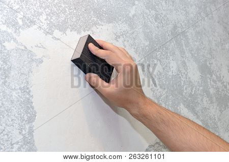 Image Of Worker Aligns The Sandpaper Wall