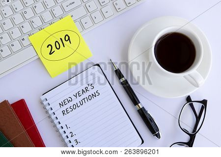 2019 New Year's Resolution Text On Notepad On Top Of White Office Desk