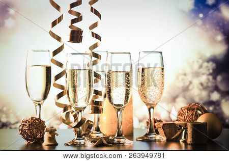 champagne glasses against holiday lights ready for New Year's eve party