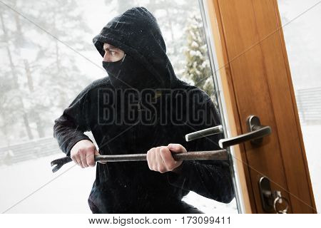 house robbery - robber trying open door with crowbar