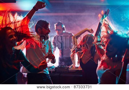 Group of dancing friends enjoying night party