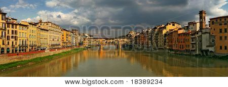 Vista panoramica su vecchie case, il fiume Arno e Ponte Vecchio a sera a Firenze, Italia.