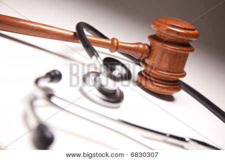 Gavel And Stethoscope On Gradated Background