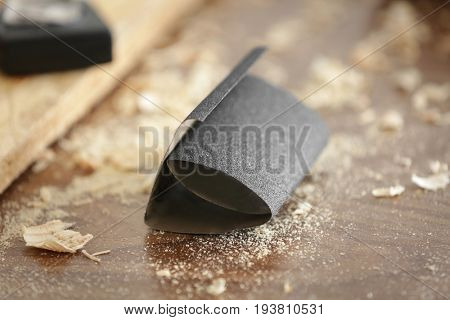 Table with sandpaper in carpenter's workshop, closeup