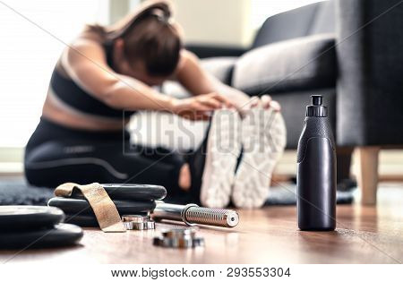 Woman Stretching Muscles Before Gym Workout And Weight Training In Home Living Room. Female Fitness 