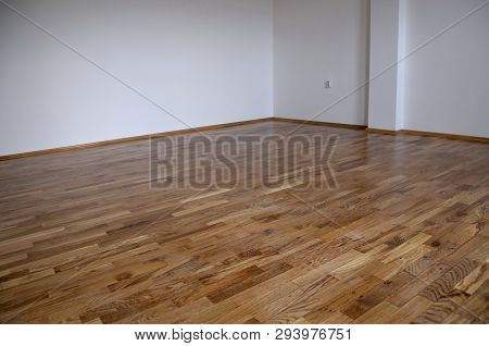 Empty Room, White Mortar Wall Background And Wood Parquet Floor In Residential. Parquet Floor Close 