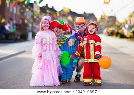 Kids And Parents On Halloween Trick Or Treat