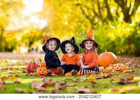 Kids With Pumpkins In Halloween Costumes