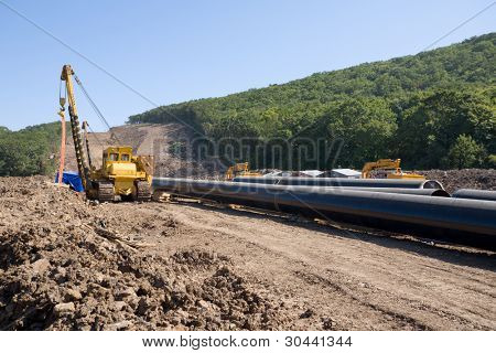 Egy új kőolajvezeték megépítése.Számítógép-csövek (pipelaying crane) a csővezeték hőálló falazó csavar