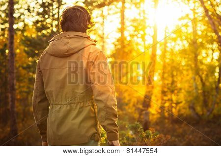 Young Man standing alone in forest outdoor with sunset nature on background Travel Lifestyle