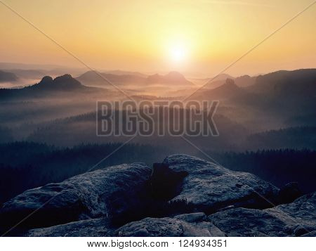 Fantastic dreamy sunrise on top of rocky mountain with view into misty valley.Mountain view.Foggy mountain.Dreamy forrest. Sunrise clouds. Forest hill.Autumn mist.Misty peaks.Foggy landscape. Rock top