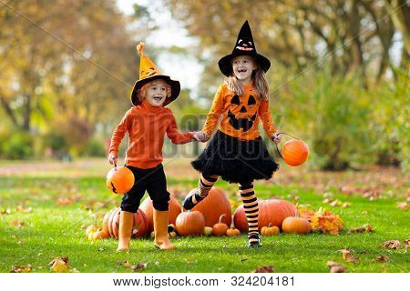 Kids With Pumpkins In Halloween Costumes