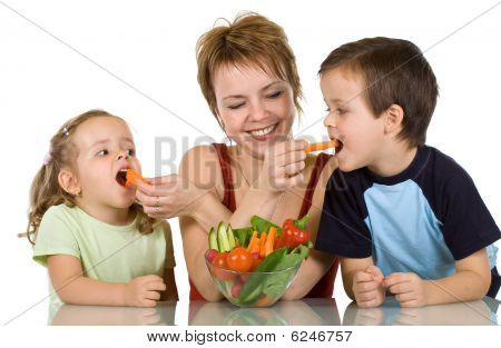 Woman Feeding Kids With Vegetables