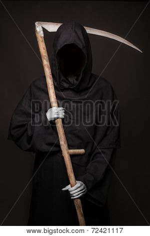 Death with scythe standing in the dark. Halloween.