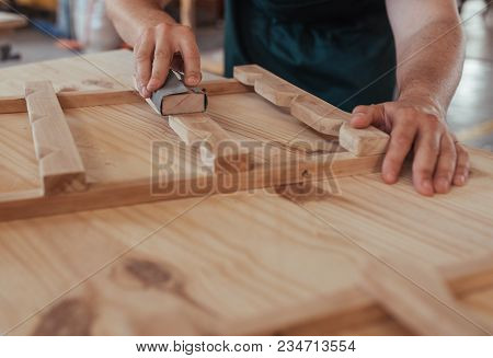 Closeup Image Of A Skilled Woodworker Hands Sanding Pieces Of A Wooden Furniture Design While Workin