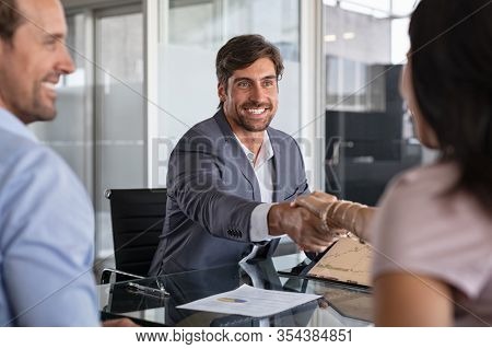 Businessman handshake during meeting, signing agreement for financial investment. Handshake of a manager with mature couple. Happy financial advisor shaking hands with his client after insurance deal.