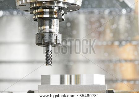 Milling machine tool with mill in chuck preparing to process metal detail at industrial manufacture factory