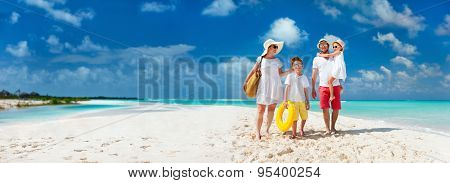 Panorama of happy beautiful family with kids walking together on tropical beach during summer vacation