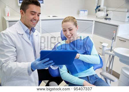 people, medicine, stomatology and health care concept - happy male dentist showing tablet pc computer to woman patient at dental clinic office