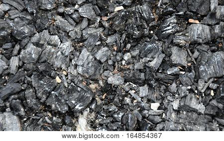 Extinct coals after bonfire. Ashes and cinders from waste burning. Black ashes or charcoal texture wallpaper. Burnt wood. black charcoal as background. The ash background.