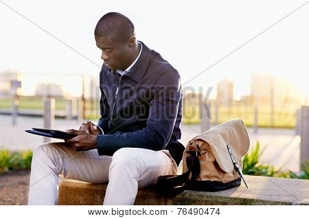 African black business man hipster using tablet computer in park on break from work