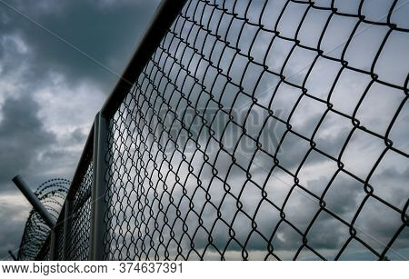 Military Zone Mesh Fence. Prison Security Fence. Looking Up View Of Barbed Wire Security Fence With 