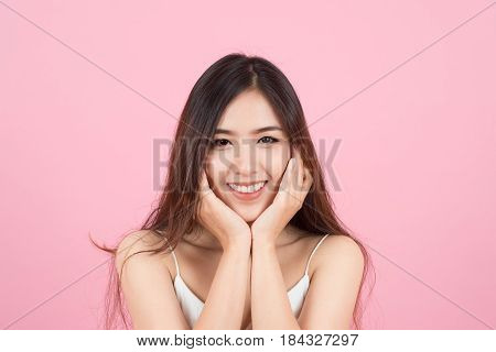 Asian young beautiful woman smiling and touch her face like a v-shape isolated over pink background. Cleaning face perfect skin. SPA therapy skincare cosmetology and plastic surgery concept